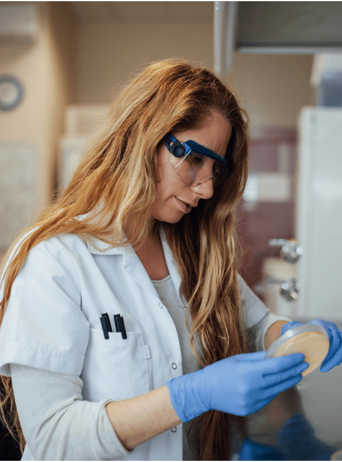 Mulheres segurando uma bandeja de amostras em um laboratório.