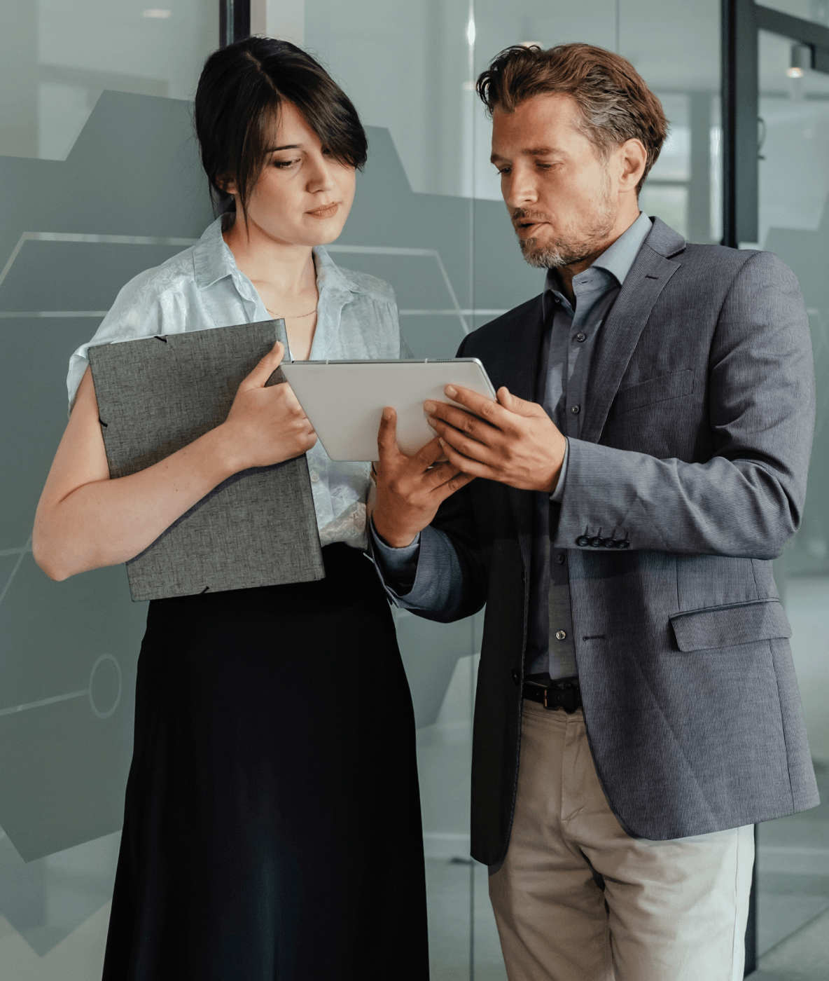 Um homem e uma mulher olhando para um tablet juntos.